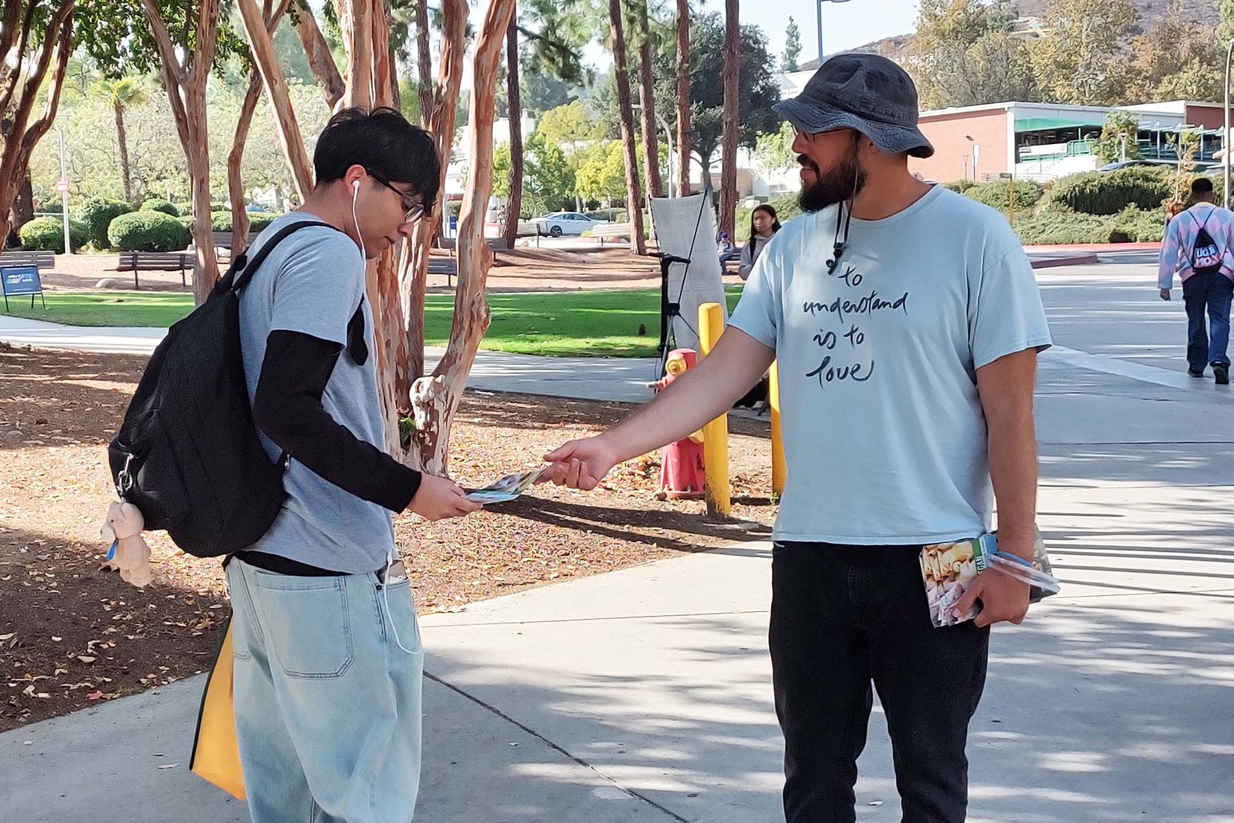 brian handing leaflet to student